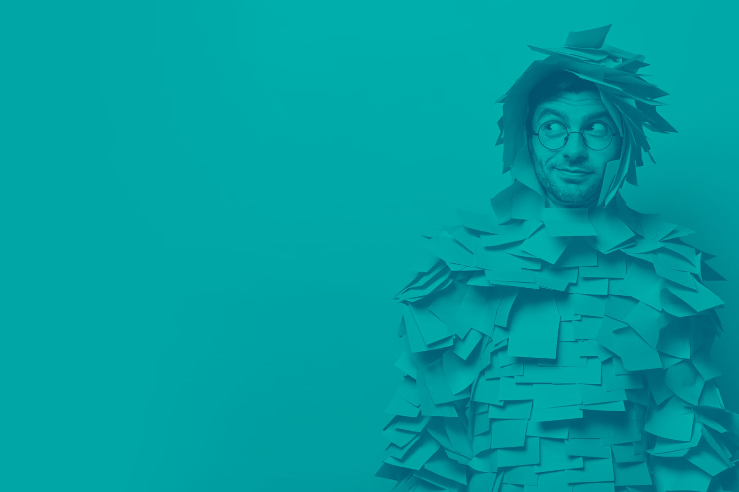 Indoor shot of male advertiser or manager covered with sticky adhesive notes, looks aside as notices something interesting, poses against yellow background, free space for your advertising content